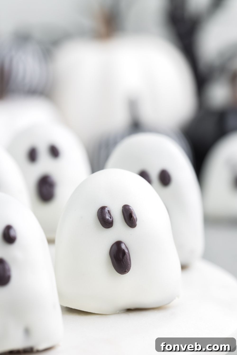 Spooky ghost Oreo truffles spread out on a table