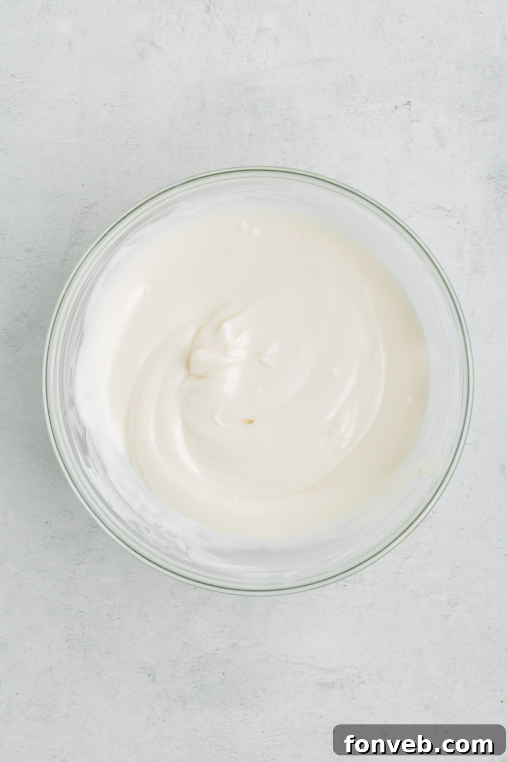 Melted white candy melts in a glass bowl on a table