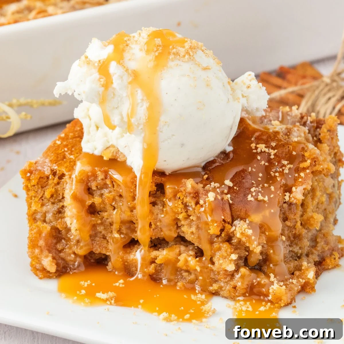 sliced earthquake cake on plate drizzled with caramel and a scoop of ice cream