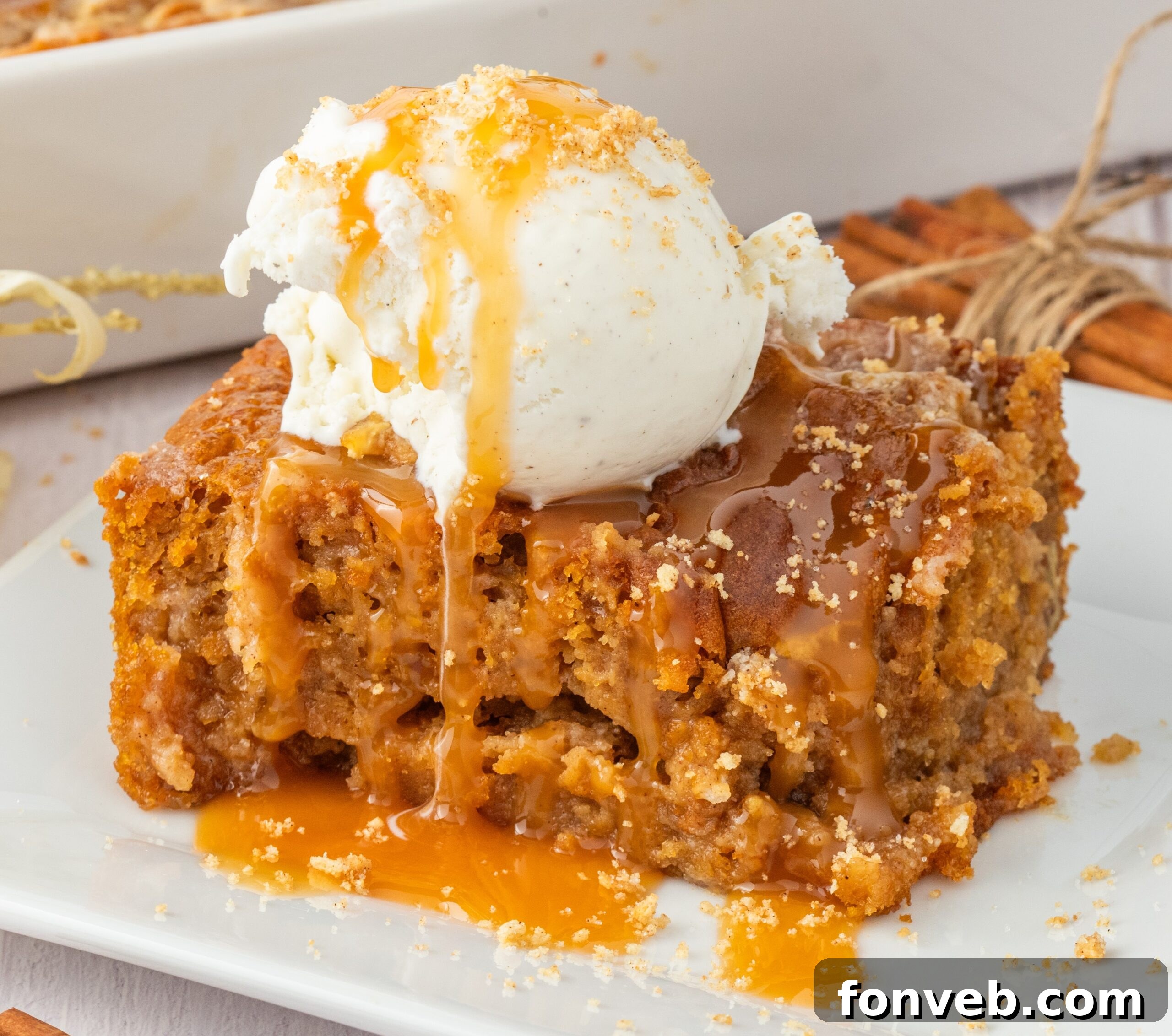 sliced earthquake cake on plate drizzled with caramel and a scoop of ice cream on top