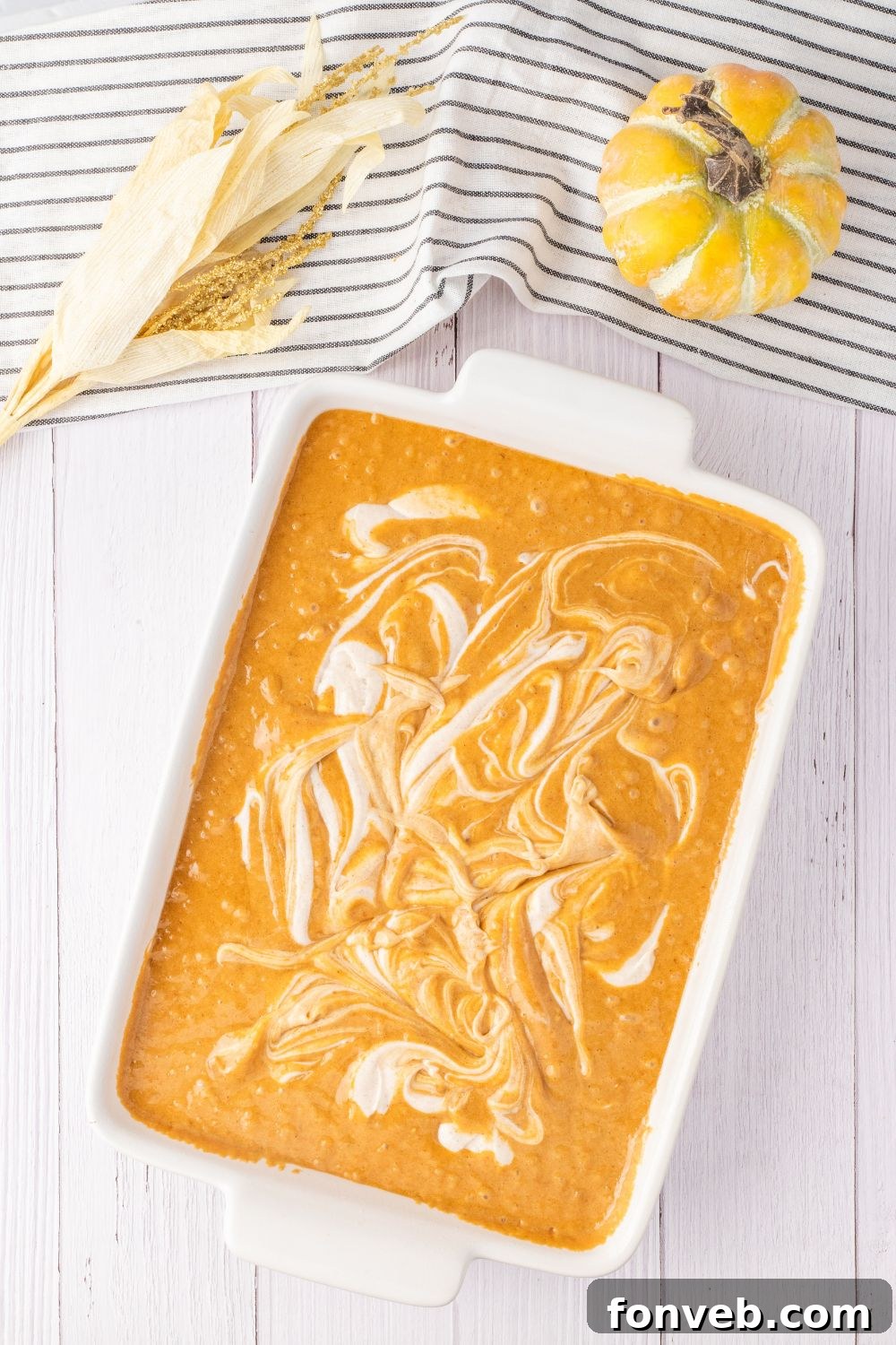 cream cheese batter swirled in pan of pumpkin cake batter