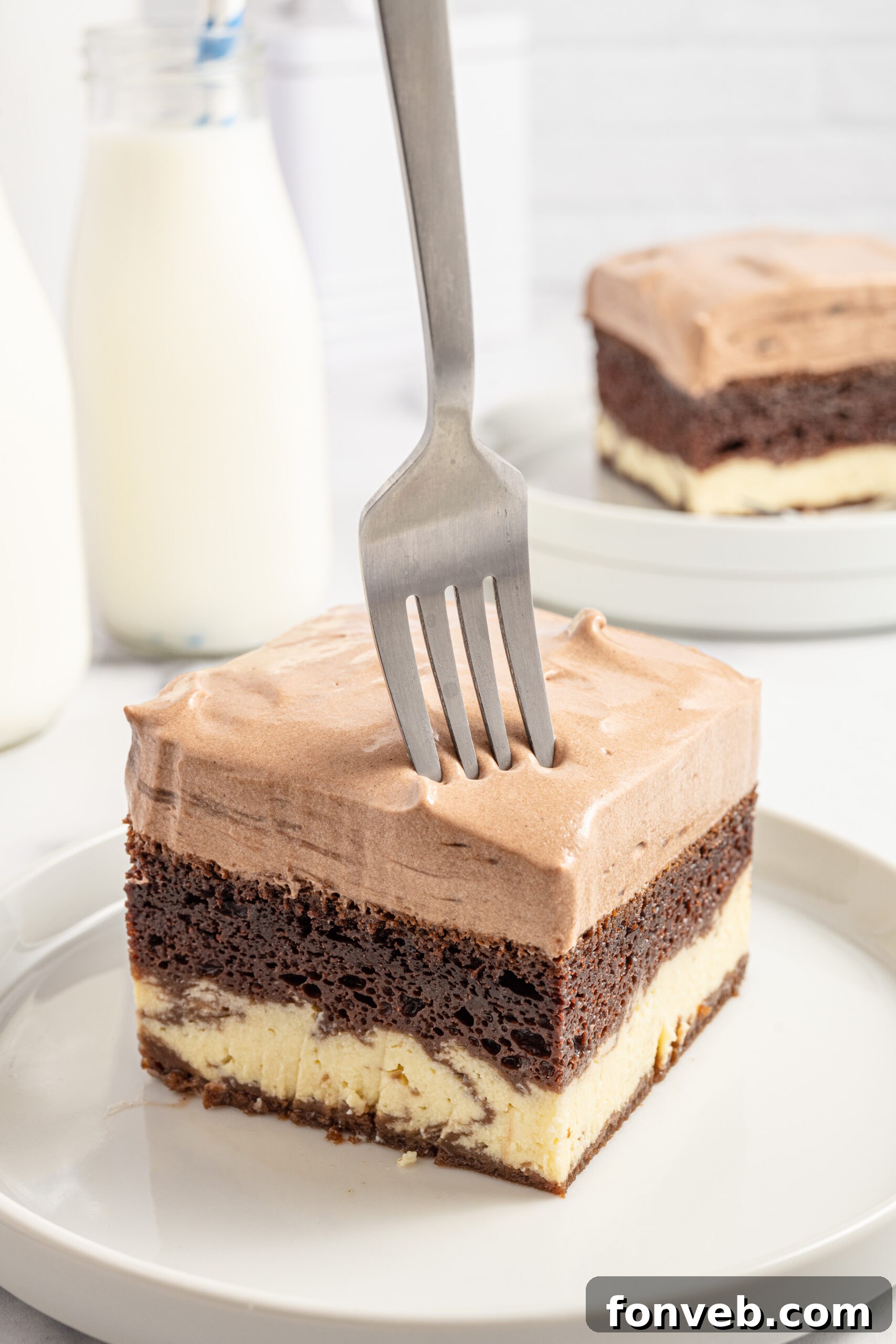 A slice of Italian Love Cake on a plate with a fork about to take a bite, showing the soft layers.