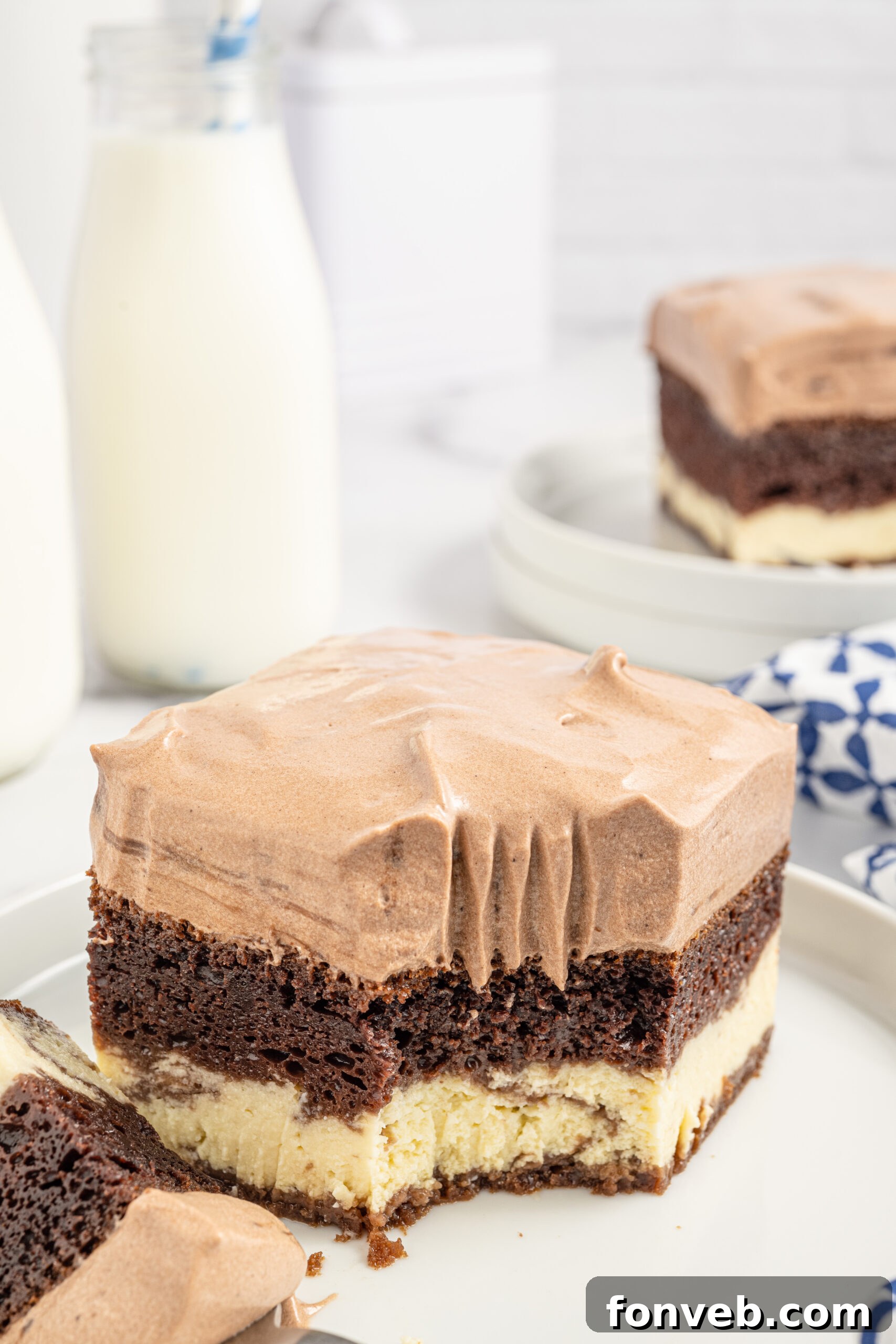 A slice of Italian Love Cake on a white plate with a fork, a bite already taken from the corner.