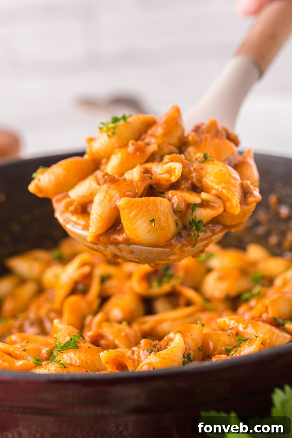 spoon of pasta over pan