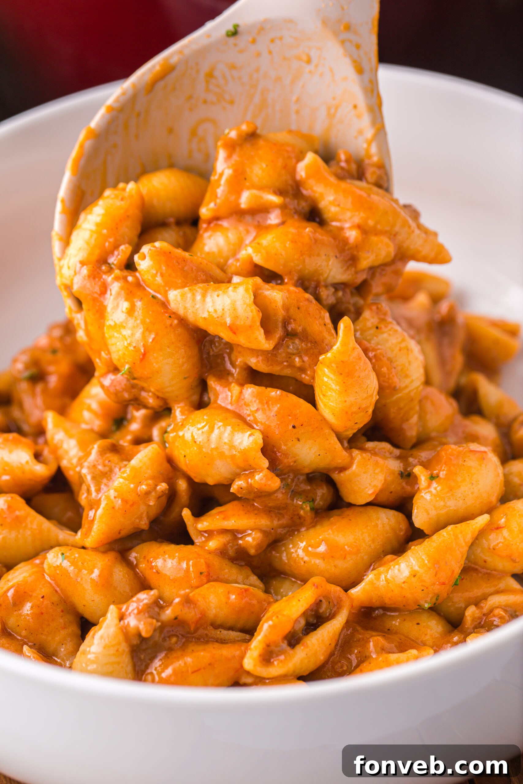 a large white spoon scooping the taco pasta into a white bowl