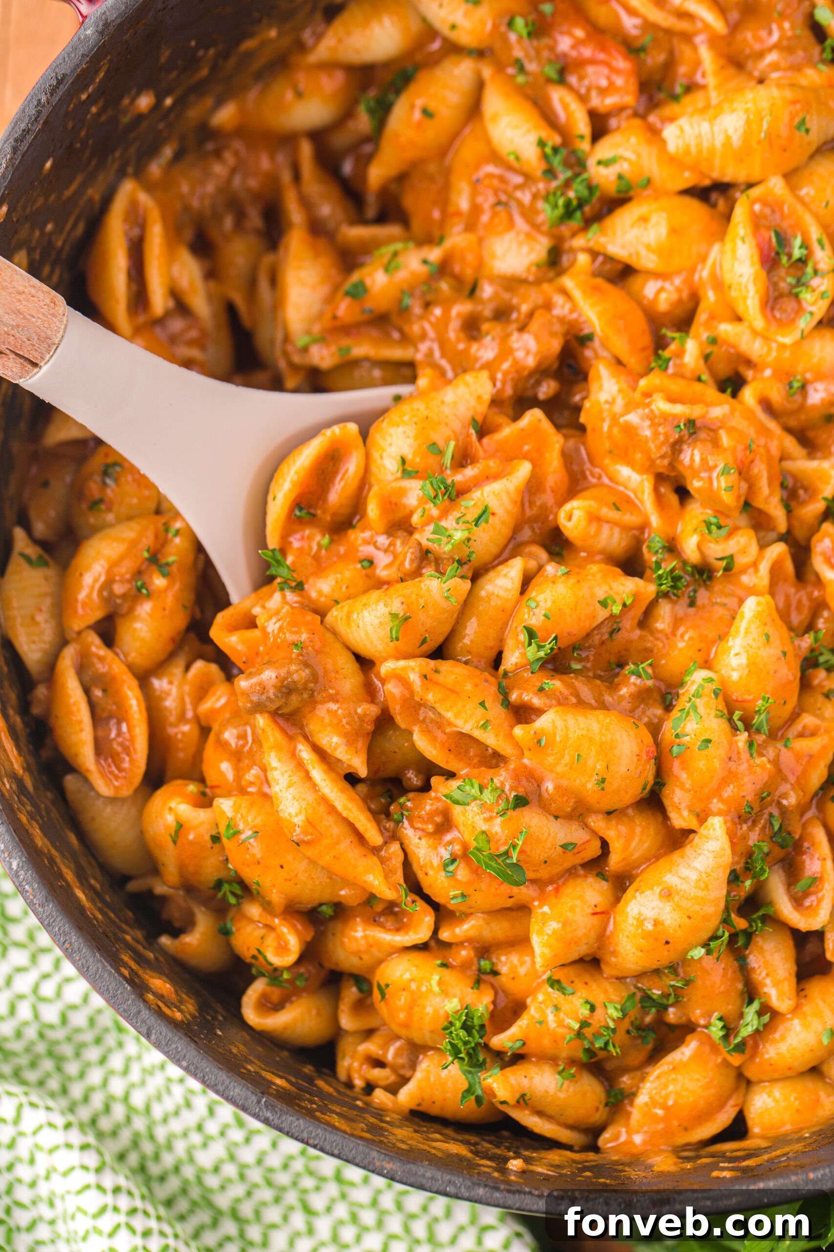 taco pasta in a skillet with a white spoon scooping some