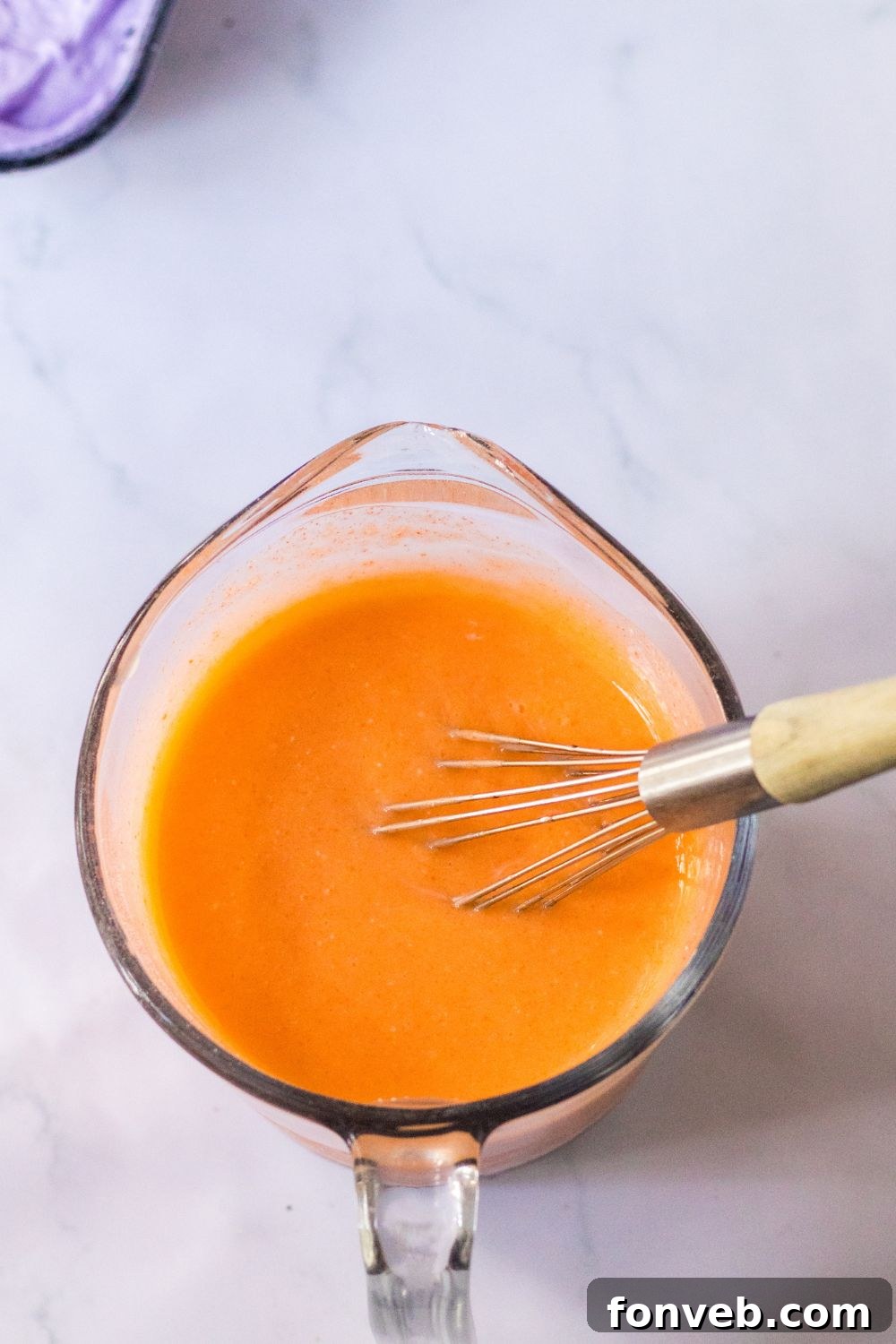 orange jello mixture in measuring cup 