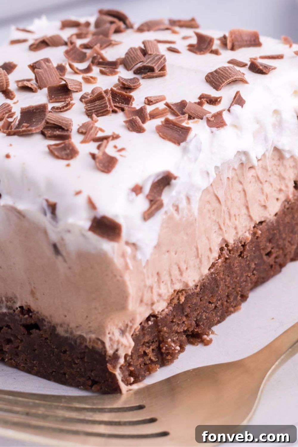 side view of brownie on plate with fork in front