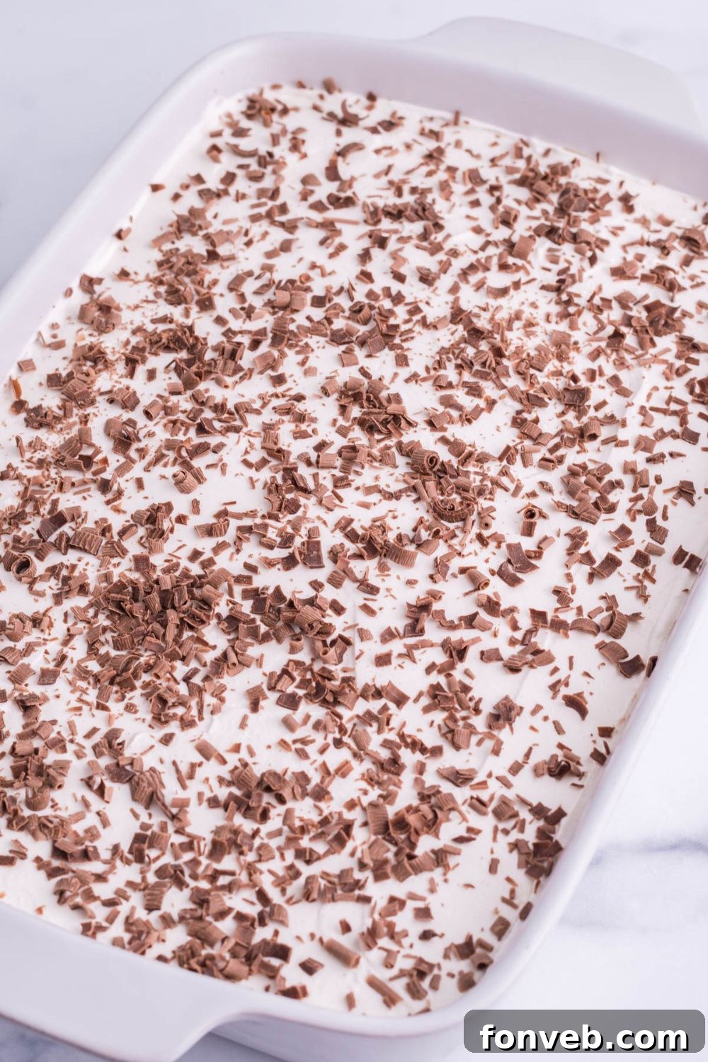 side view of brownies topped with whipped cream and chocolate shavings