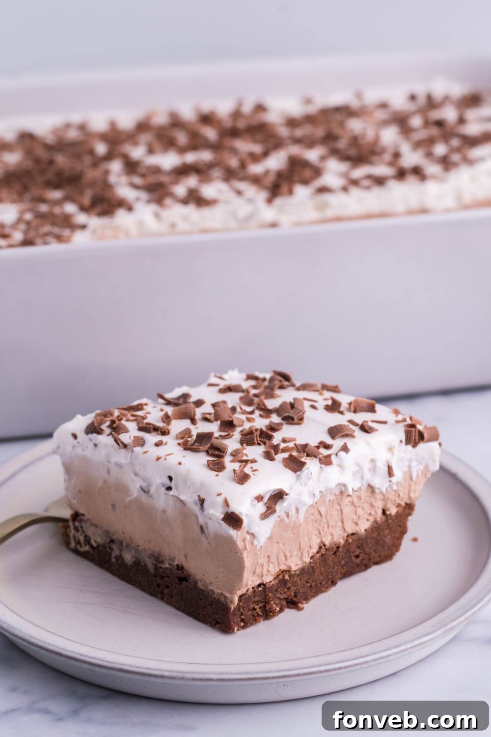 french silk cake sliced on plate with pan behind it