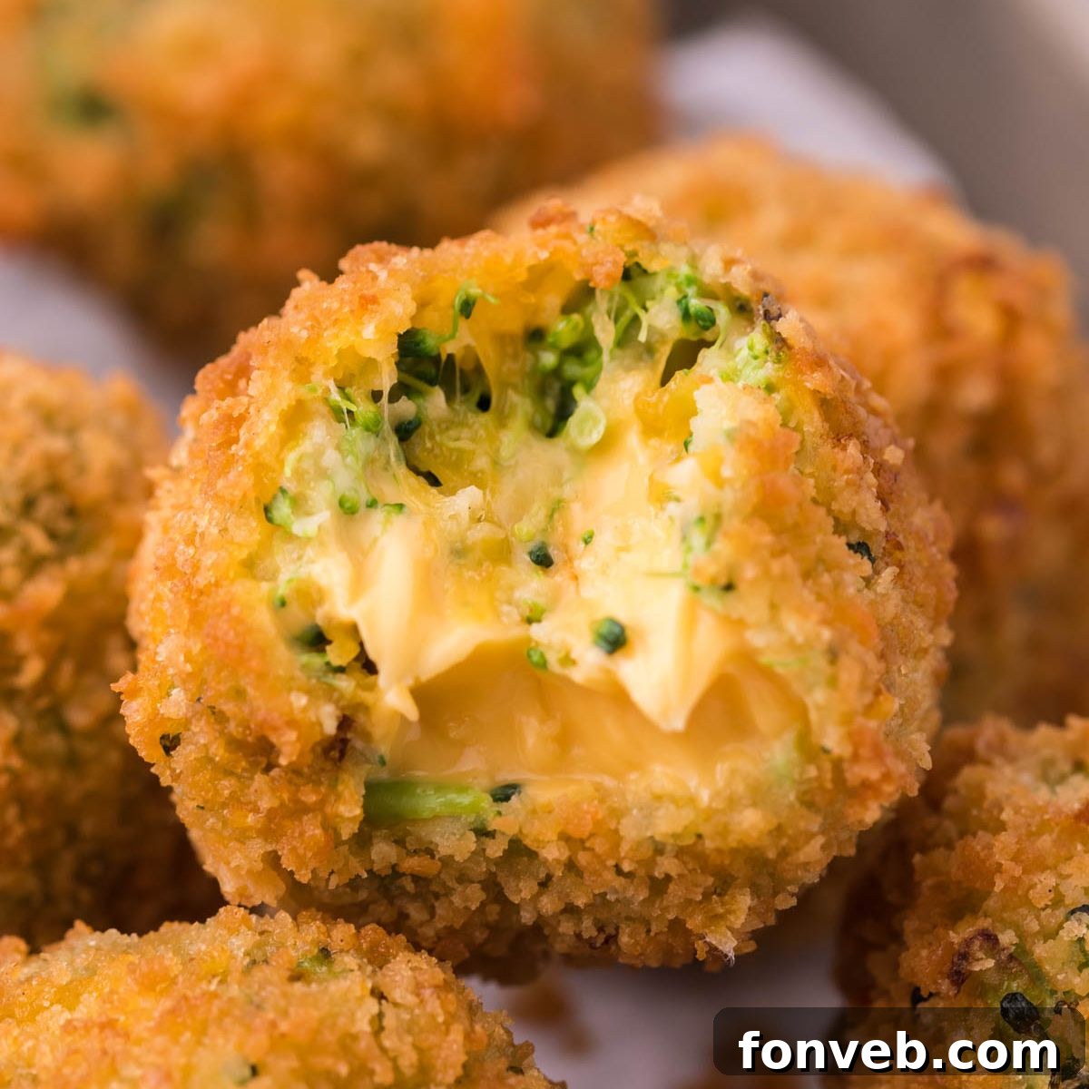 Crispy Fried Broccoli Poppers 4 bite taken out of a fried broccoli bite stacked on counter