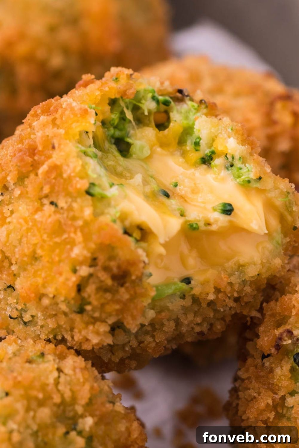 Crispy Fried Broccoli Poppers 8 brocoli bite with bite taken out sitting on top of other broccoli bites