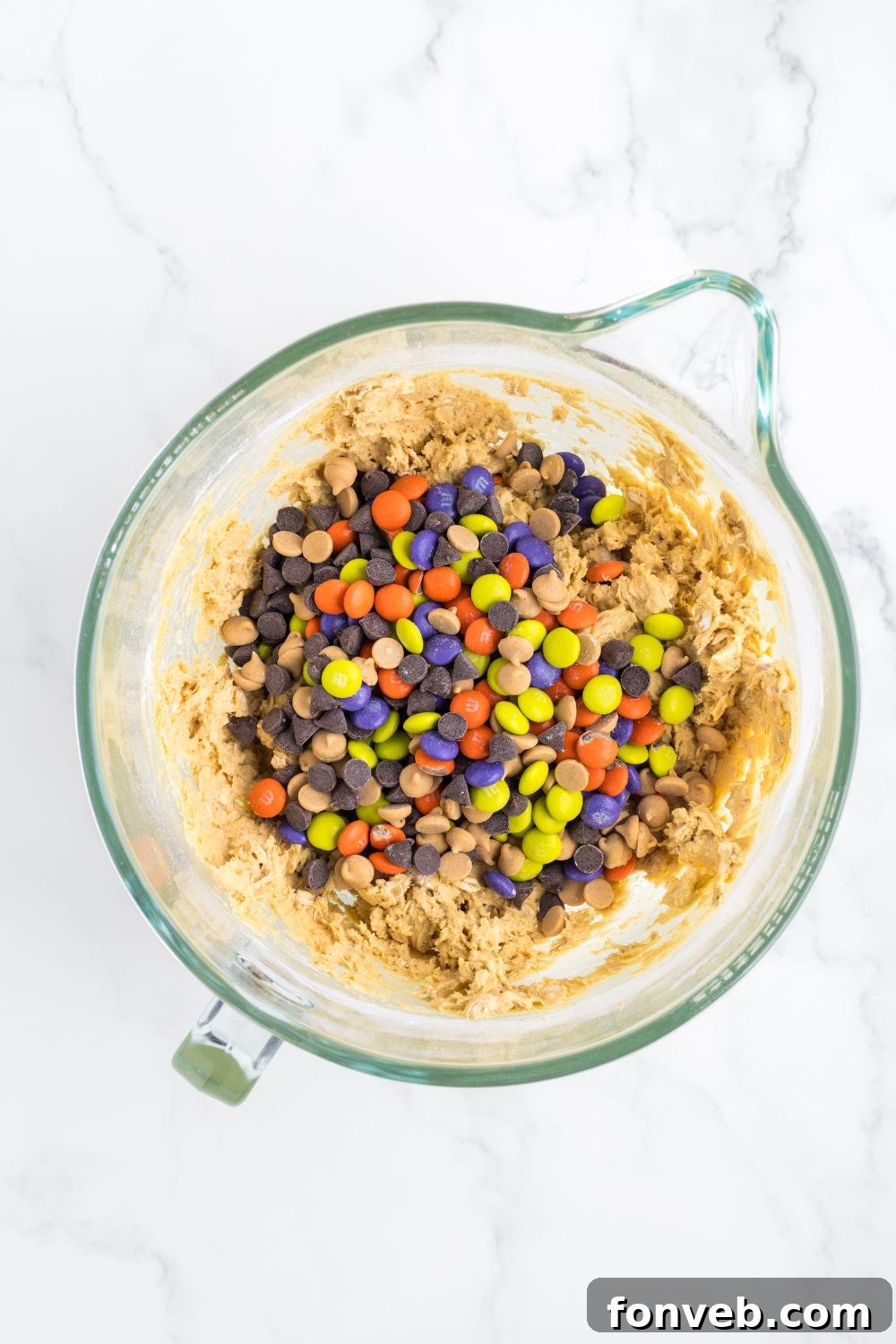 Cookie dough with M&M's mixed in, visible in a mixing bowl.