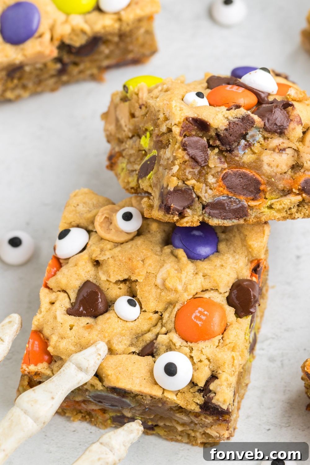 Cookie bars arranged on a table with a skeleton Halloween decoration nearby, enhancing the spooky ambiance.