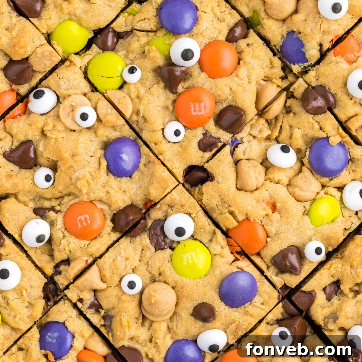 Halloween Monster Cookie Bars neatly sliced and arranged in a baking pan, seen from an overhead perspective.