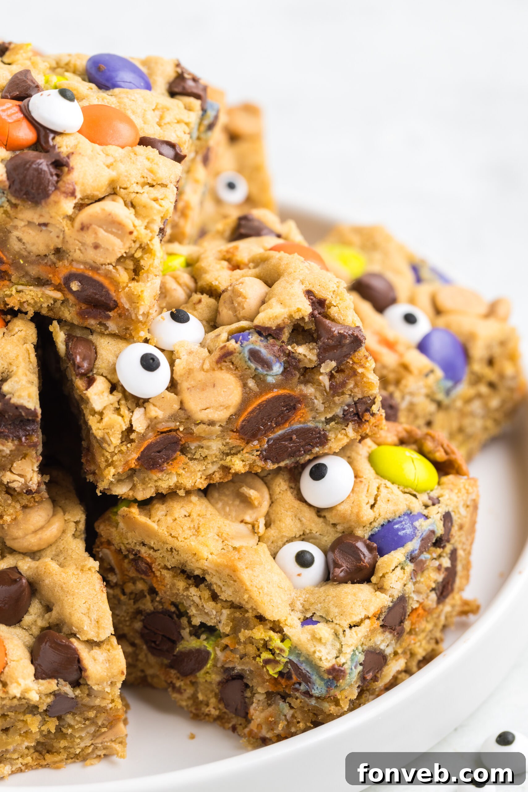 Fall-themed cookie bars stacked on a rustic platter on a table, surrounded by autumnal decor.