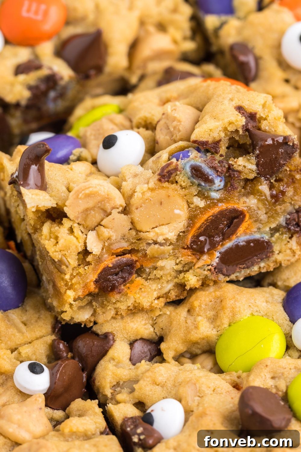 Several cookie bars neatly stacked on top of each other in a baking pan, highlighting their thickness and texture.