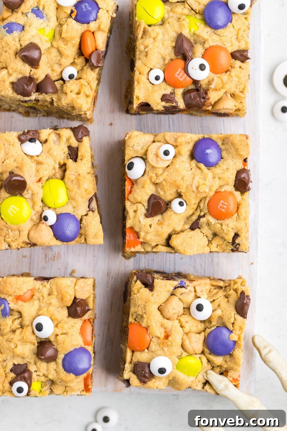 Halloween Monster Cookie Bars artfully arranged on a table with various Halloween decorations, creating a festive display.