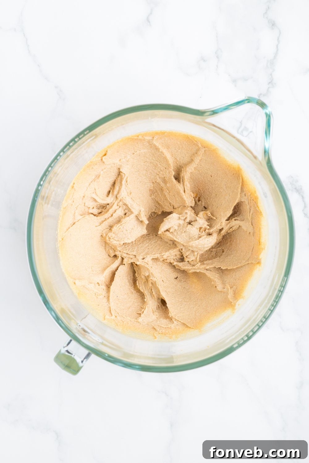 Creamed butter and sugar in a large measuring cup, showing a light and fluffy texture.