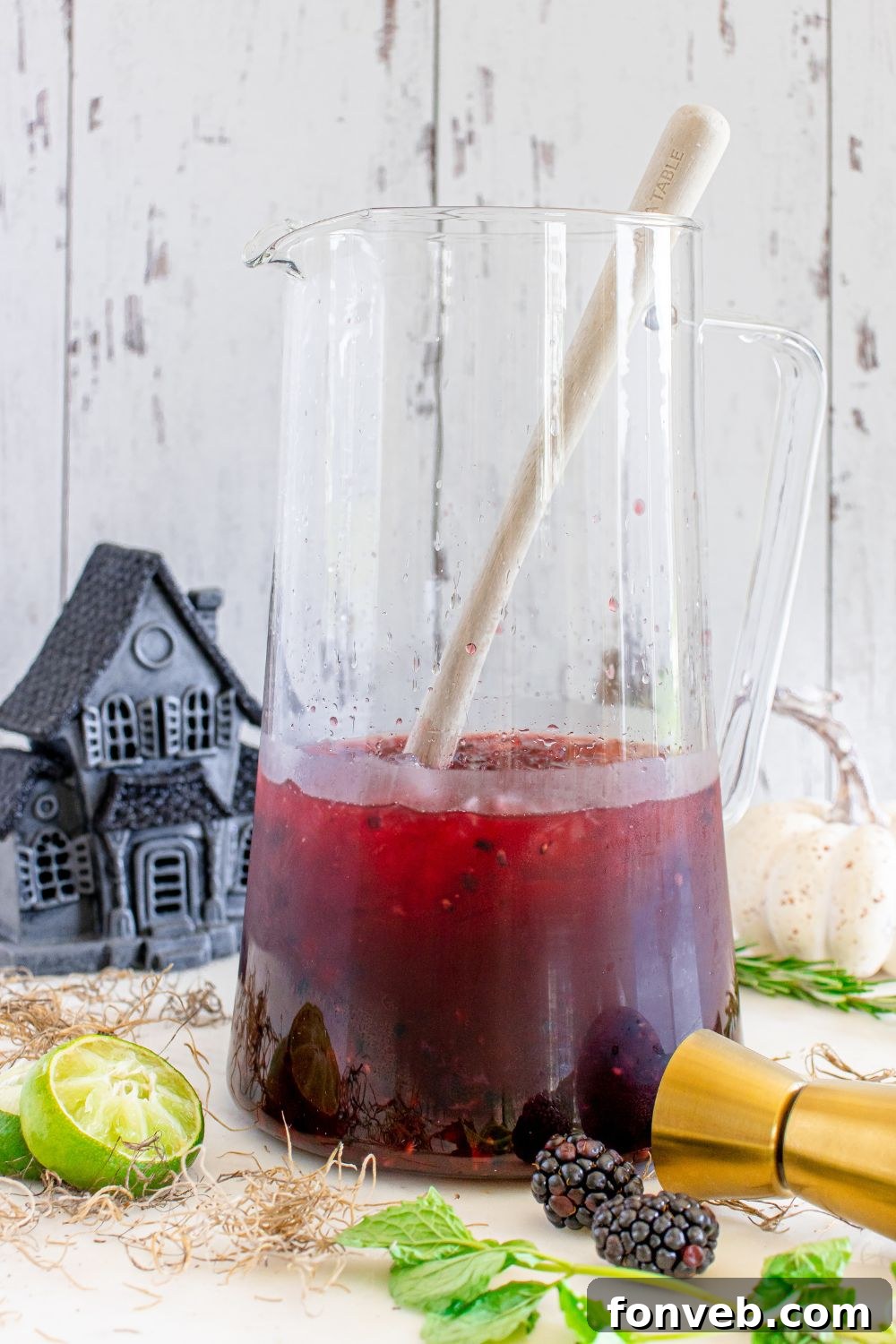 Magic Potion Margarita 11 A partially mixed margarita in a stirring glass, surrounded by fresh garnishes like lime and blackberries, ready for the final pour.