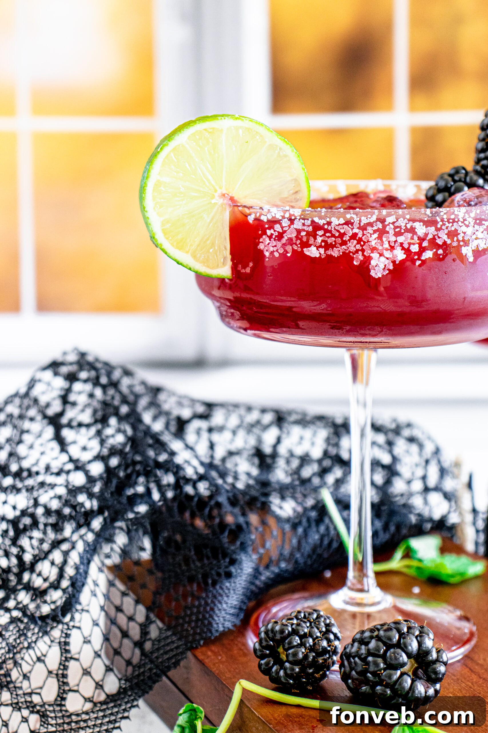 Magic Potion Margarita 14 A Sanderson Sisters Margarita sitting on a kitchen counter, bathed in soft lighting, highlighting its rich color.