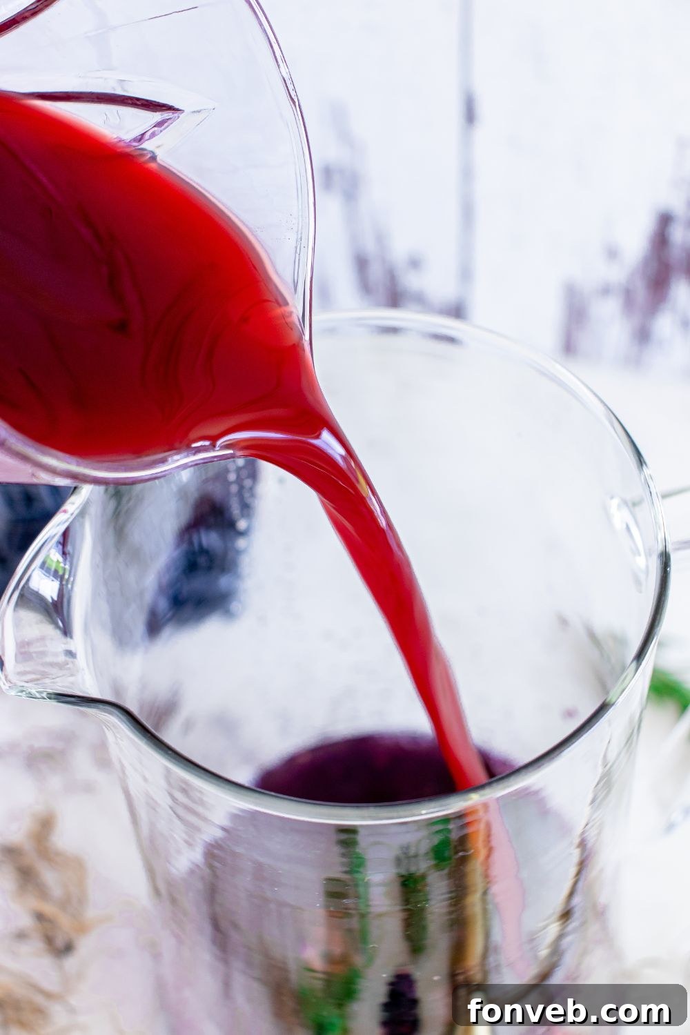 Magic Potion Margarita 8 Pomegranate juice being poured into a cocktail glass, showcasing its rich color.