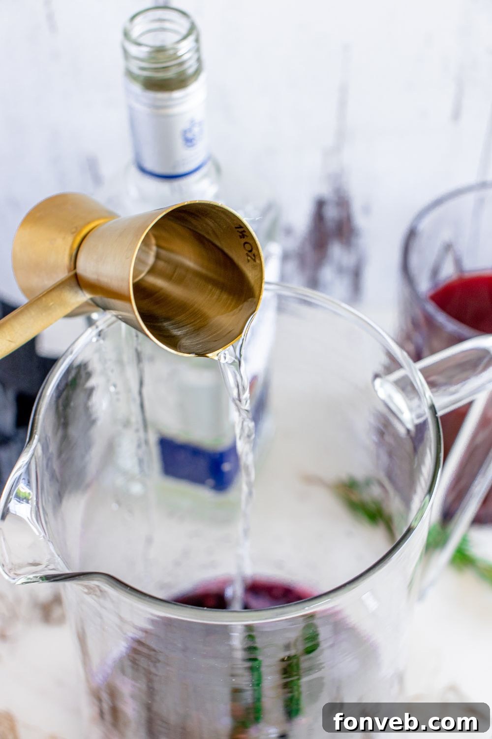 Magic Potion Margarita 10 Blanco tequila pouring from a shot glass into a mixing container, showing the clear spirit.