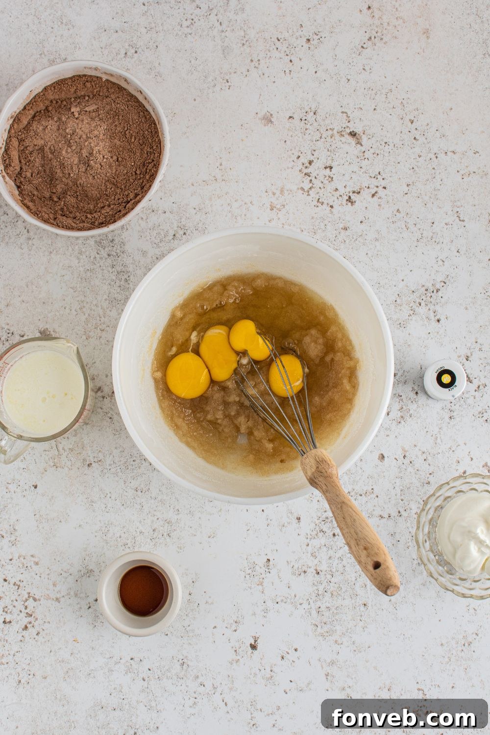 Eggs and wet batter in a mixing bowl, showcasing the start of the cupcake batter preparation.