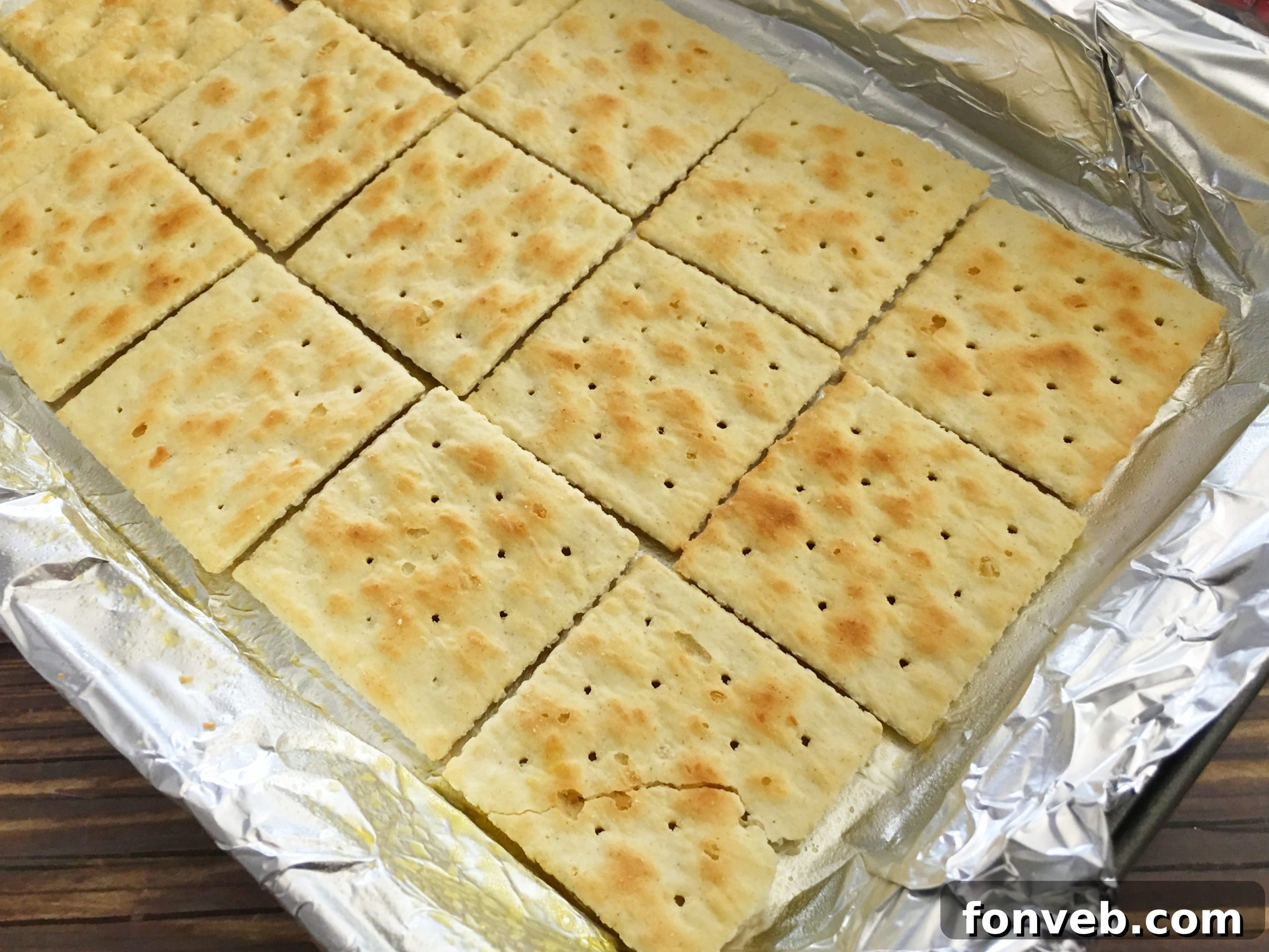 Toffee mixture being poured evenly over a layer of saltine crackers in a baking pan