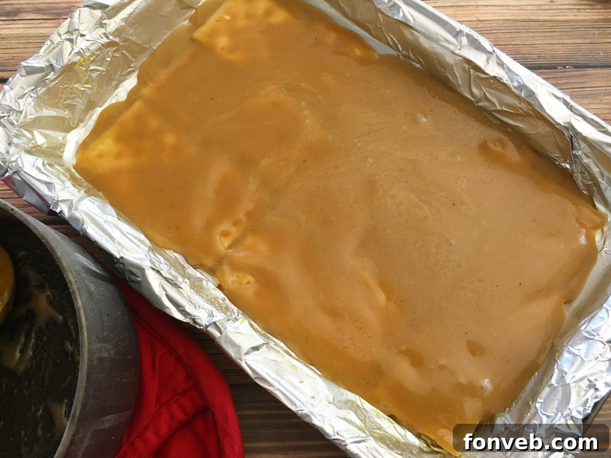 Close-up of saltine crackers coated in golden toffee, ready for the next step
