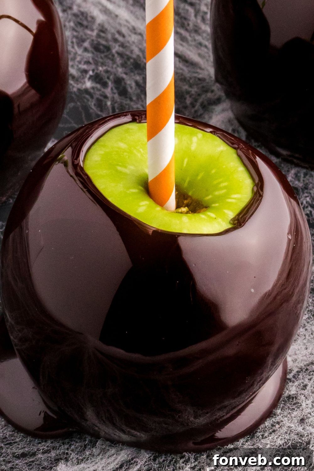 halloween candied apple on table with paper straw in it
