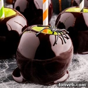 Black Candy Apples on table with fake spider sitting on top of it