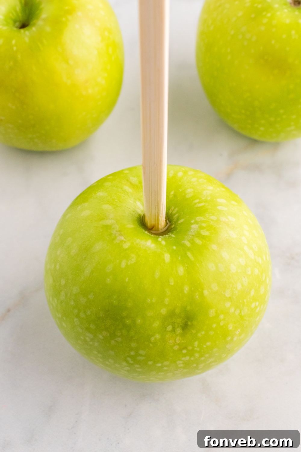 Granny Smith apples with a wooden skewer poked in top