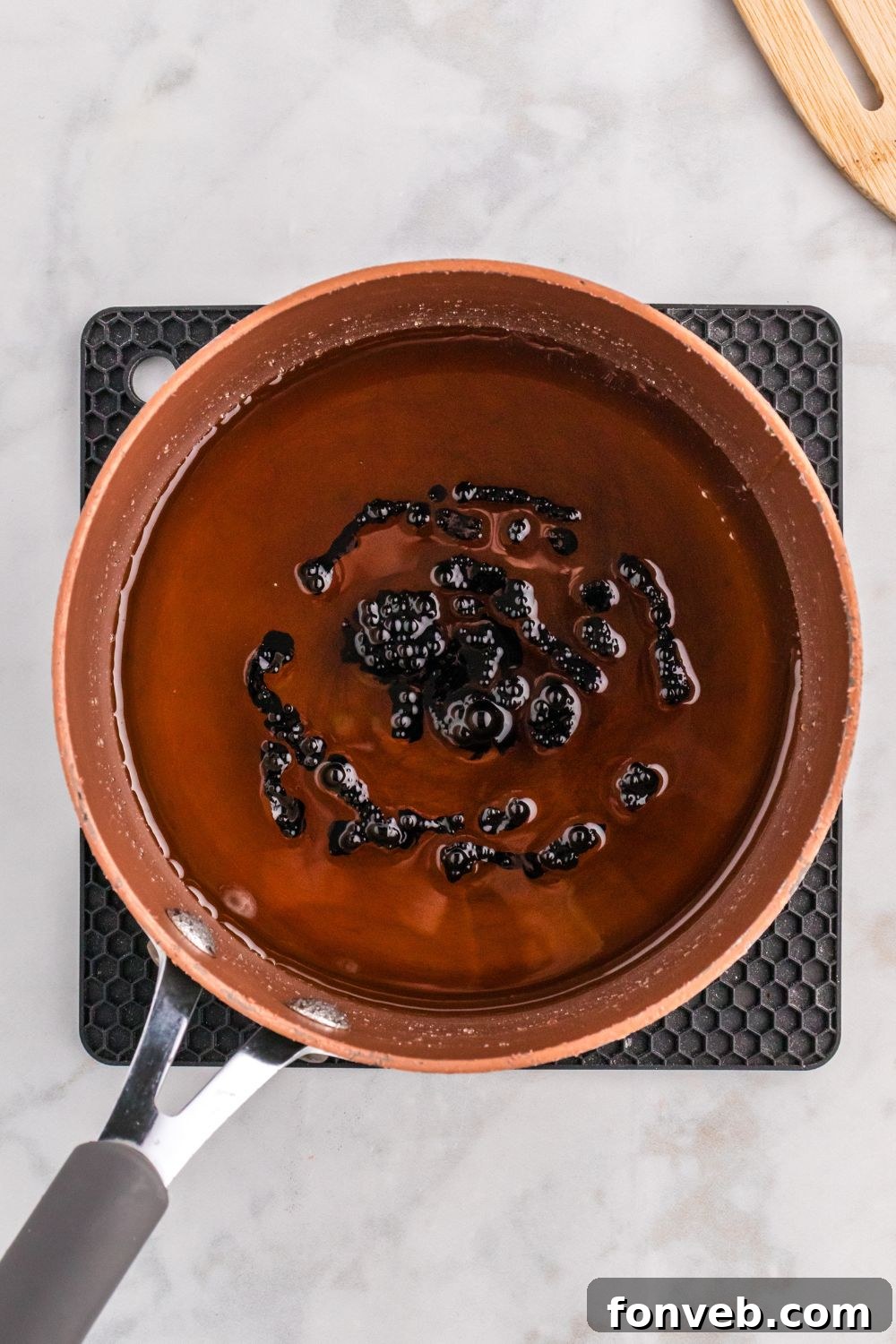 black food coloring added to pan of candy coating for apples