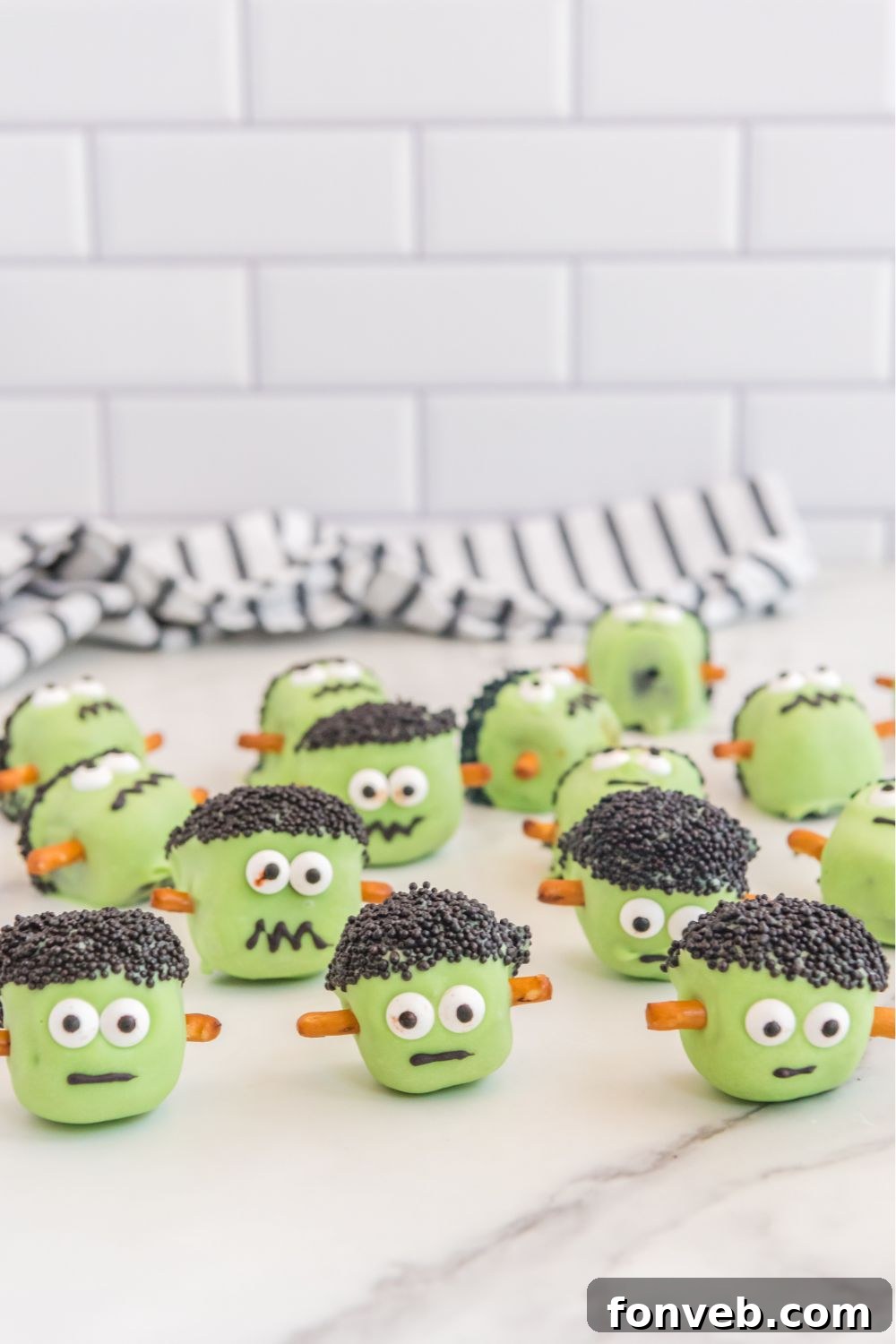 FrankenOreo Bites 3 halloween oreo balls designed to look like frankenstein on table