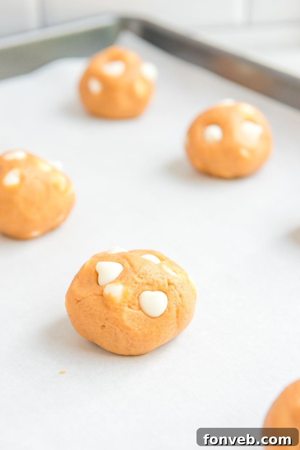 pumpkin cookie dough balls on cookie sheet