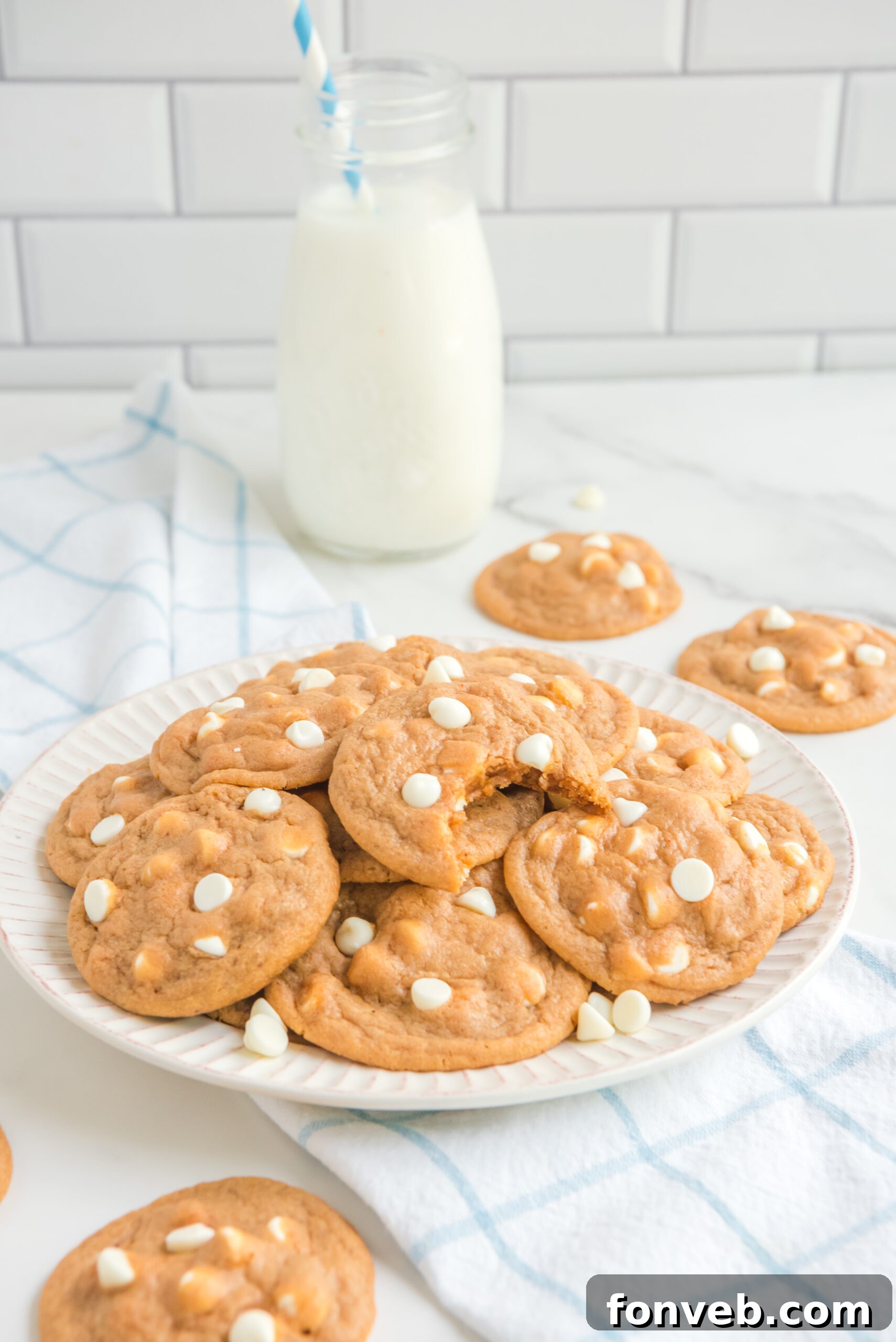 Pumpkin Spice Pudding Cookies on a white plate with the top cookie missing a bite