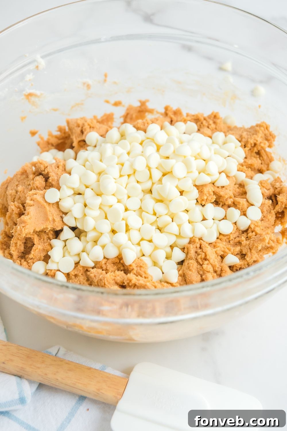 white chocolate chips on top of the pumpkin cookie dough 