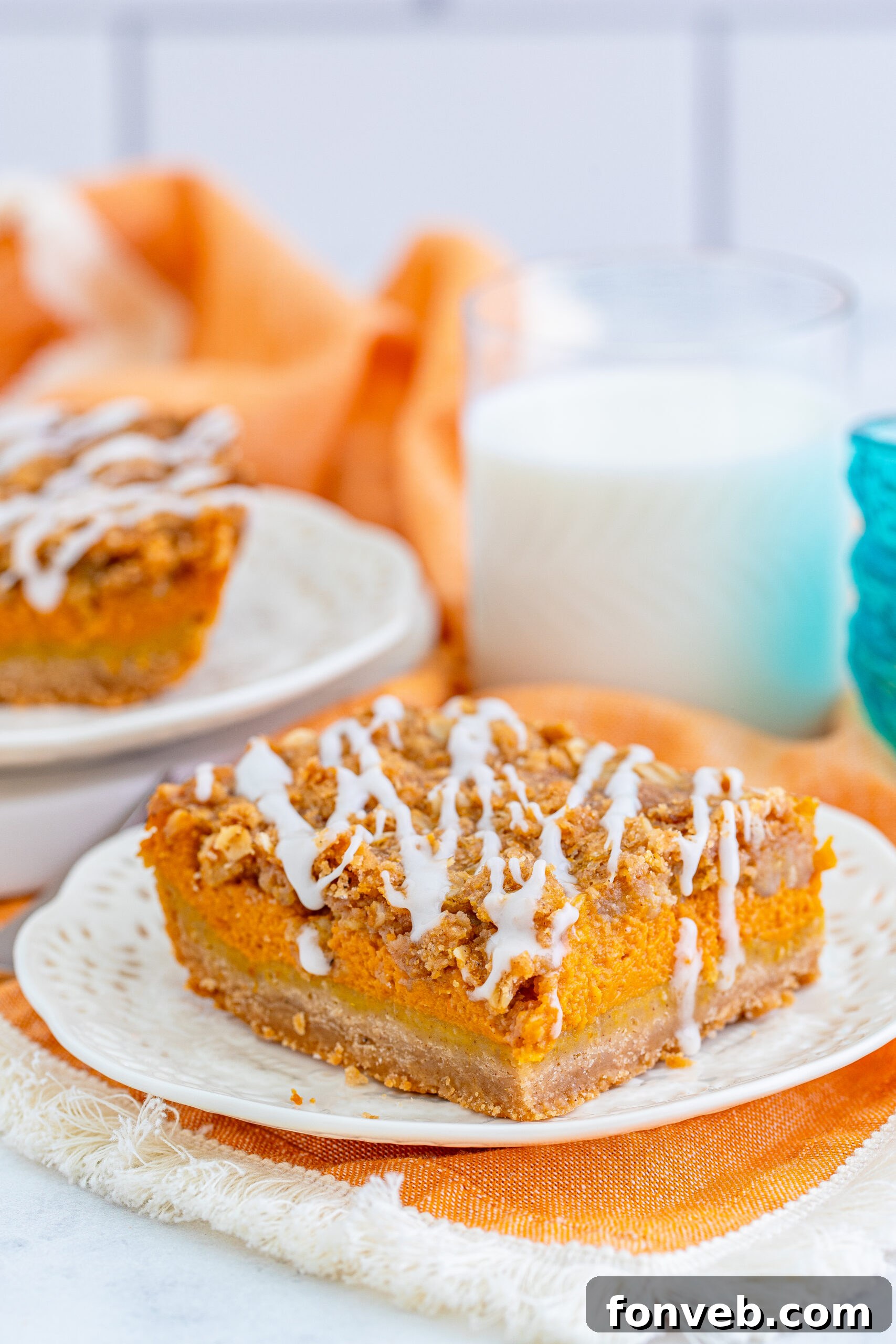 Pumpkin Streusel Bars on a white plate with a glass of milk next to it