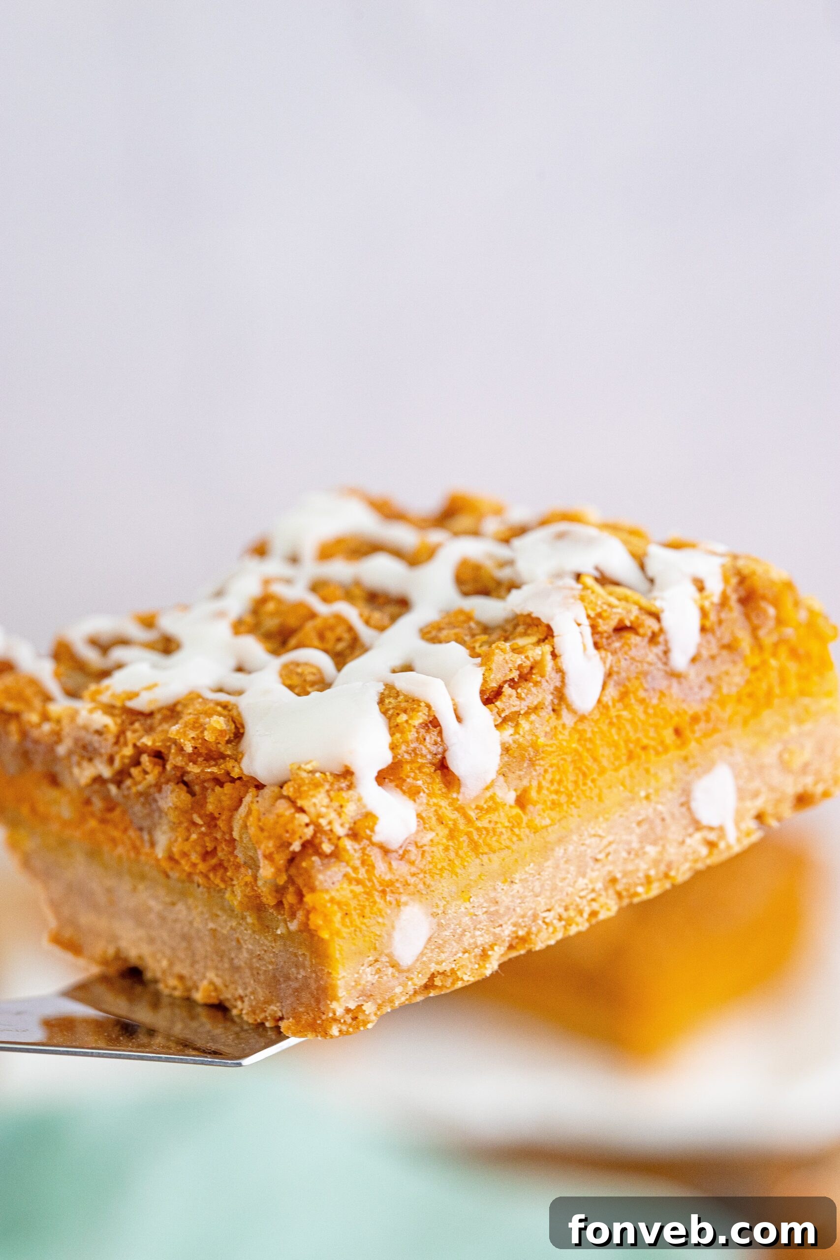 Pumpkin Streusel Bars on a spatula aboe the pan