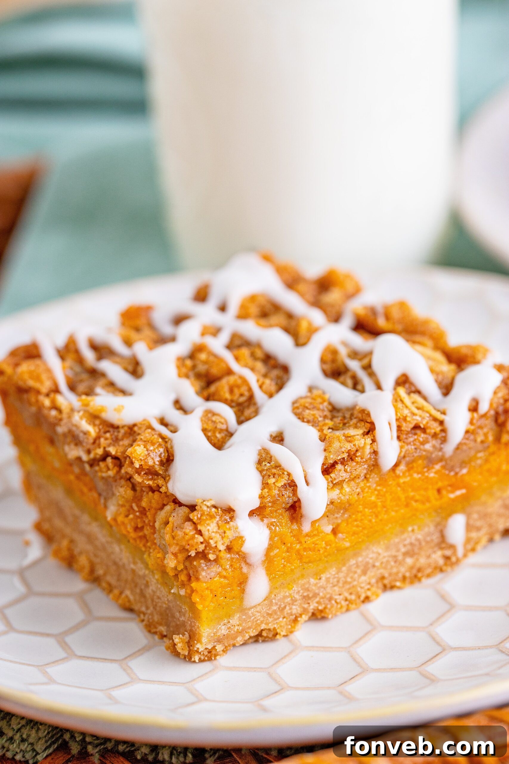 side view of pumpkin streusel bar on plate with milk