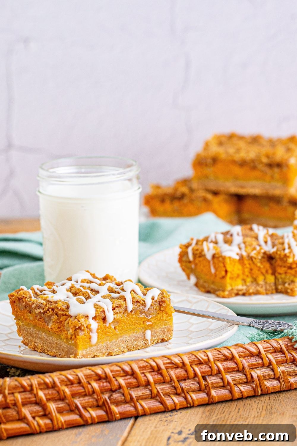 streusel pumpkin bars on a serving tray with a glass of milk behind it