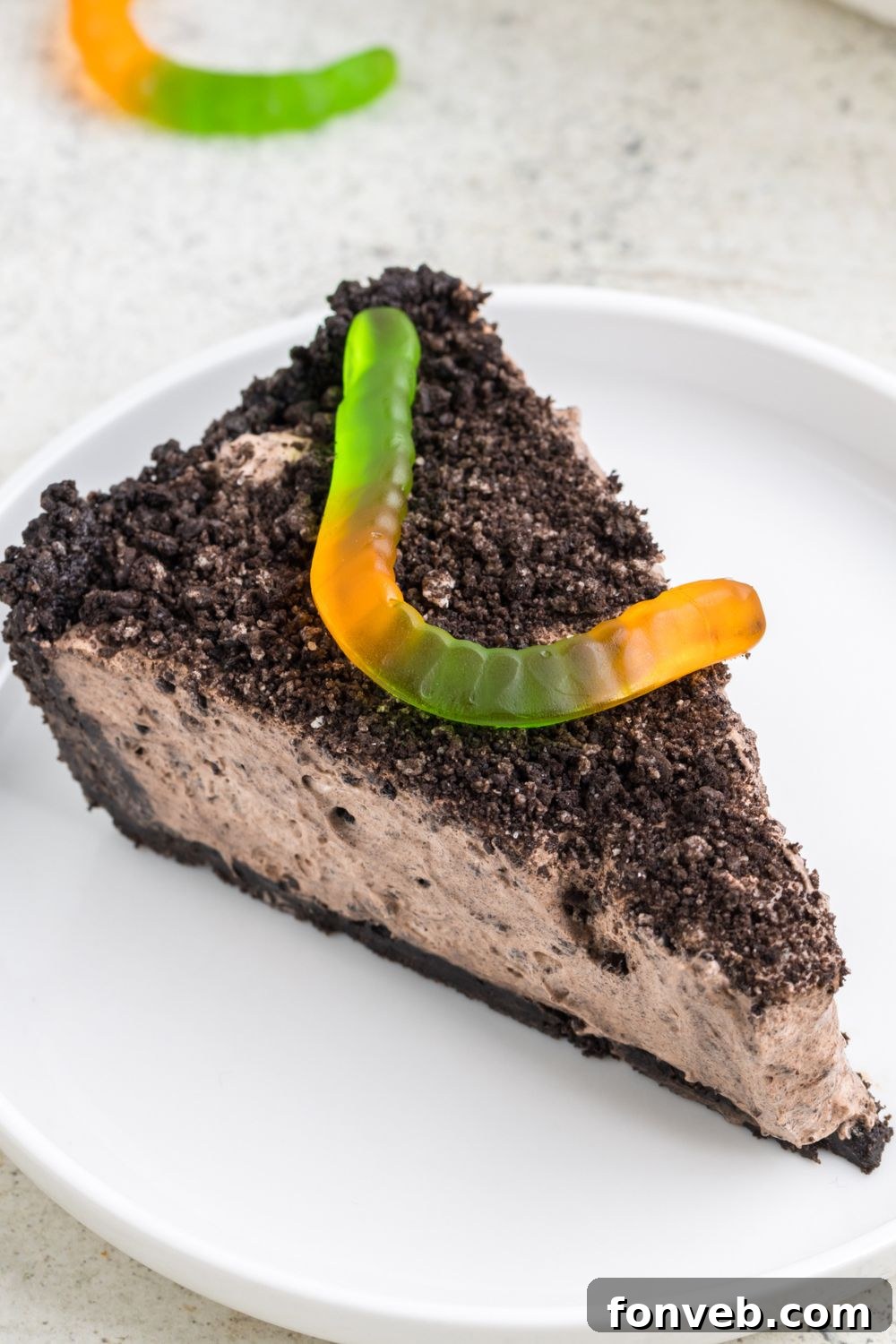 slice of dirt pie on plate with a gummy worm on top