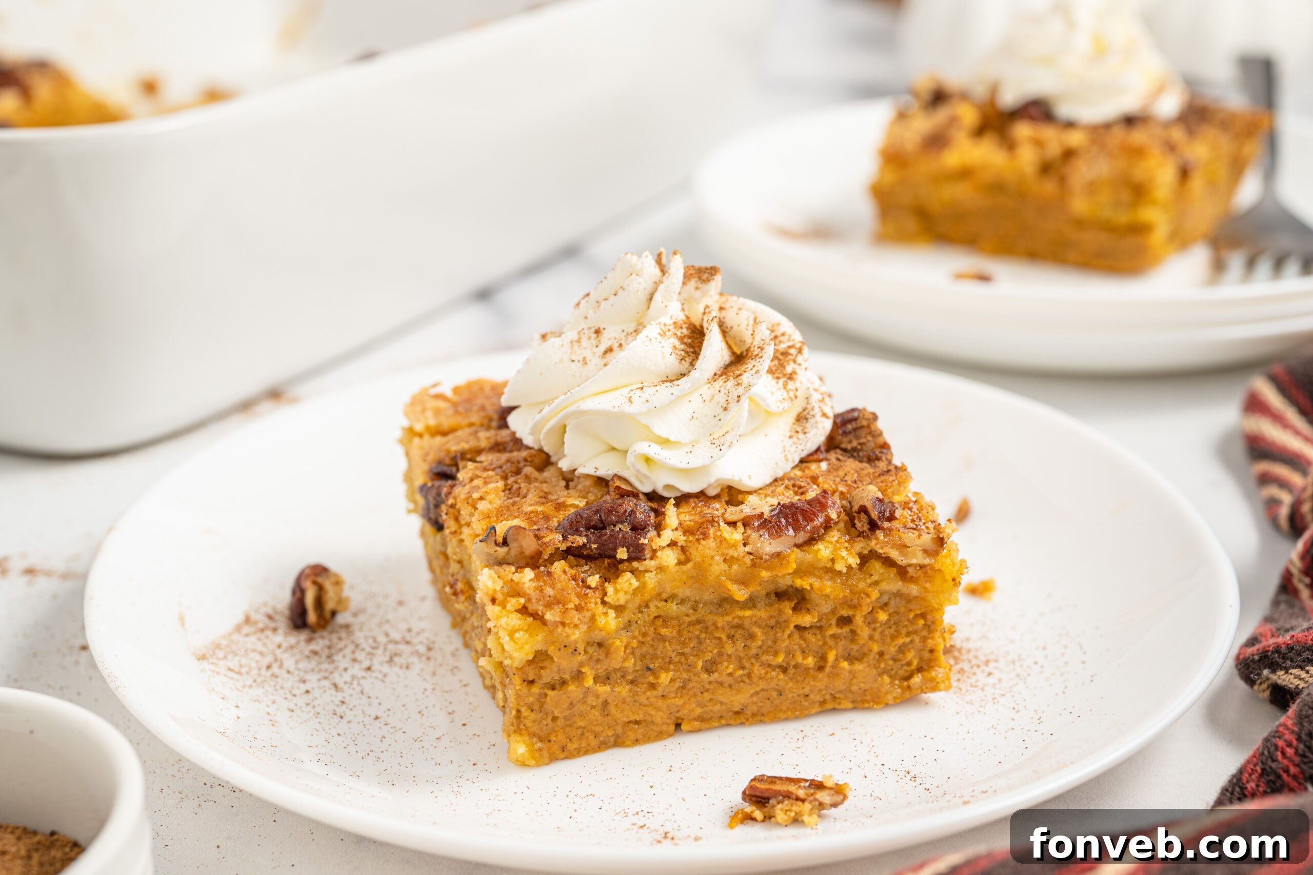 A full Pumpkin Dump Cake in a white baking dish, set on a dark wooden table, with warm lighting emphasizing its inviting, golden-brown crust.