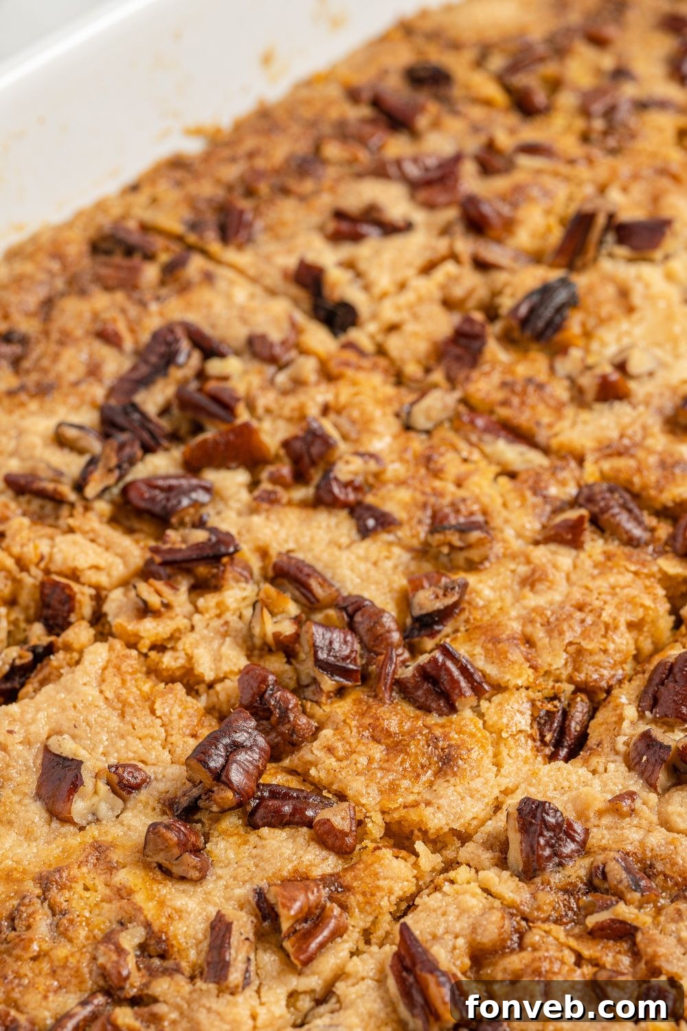 A close-up, inviting view of a full Pumpkin Dump Cake still in its baking pan, showcasing its golden, crumbly top and warm presentation.