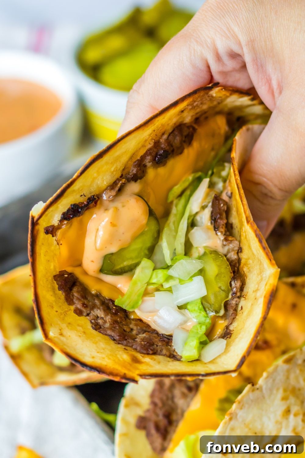 Smashed Big Mac Tacos 11 A hand holding a Big Mac smash taco, showing off the generous fillings