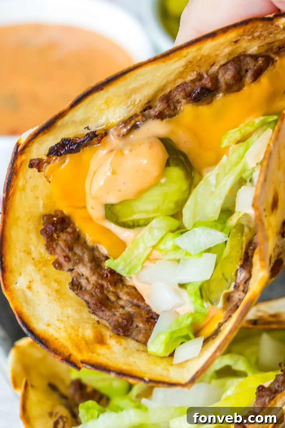 Smashed Big Mac Tacos 13 A hand holding a delicious Big Mac taco, showcasing its handheld appeal