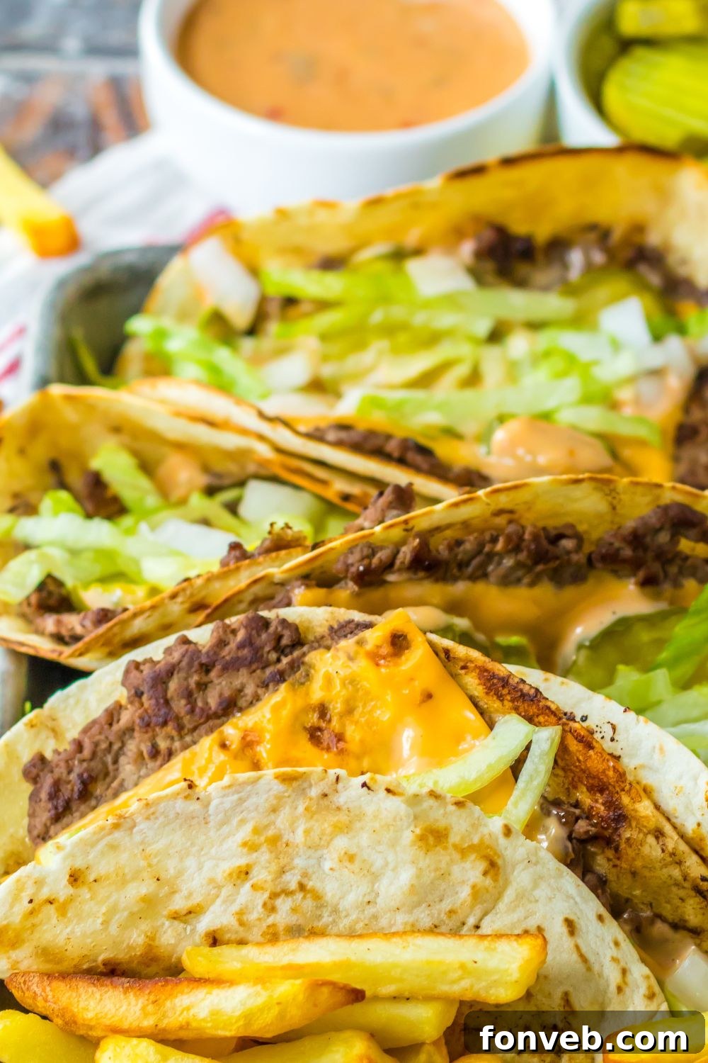 Smashed Big Mac Tacos 19 Easy Big Mac smash tacos on a plate with sauce in a container behind it
