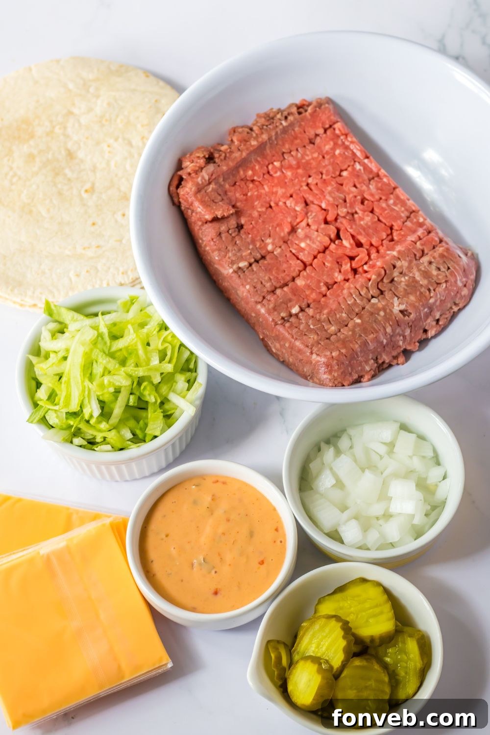 Smashed Big Mac Tacos 5 Ingredients for Big Mac tacos laid out on a wooden table