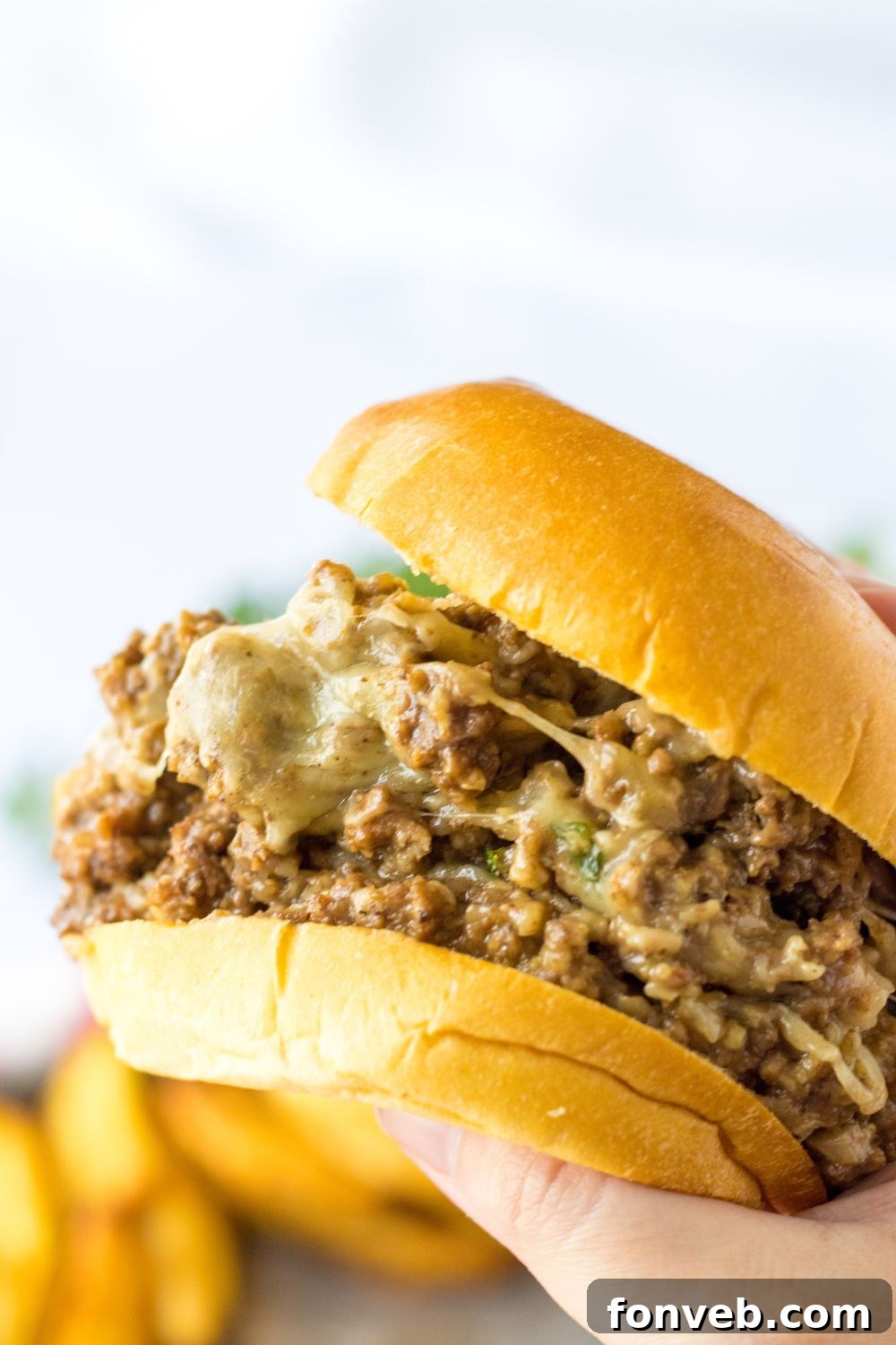 holding a french dip sandwich in hand